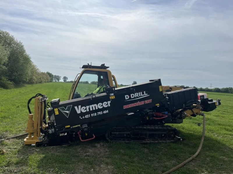 Vrtná súprava Vermeer s polepom D-Drill na lúke.