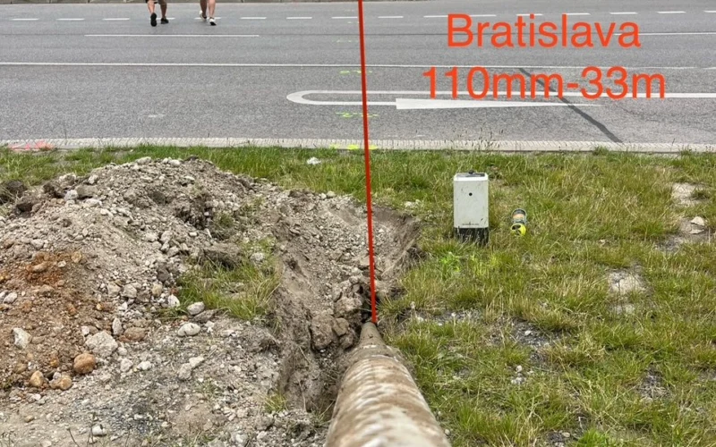 Potrubie vyvedené do zeleného pásu po pretlaku popod mestskú komunikáciu v Bratislave.