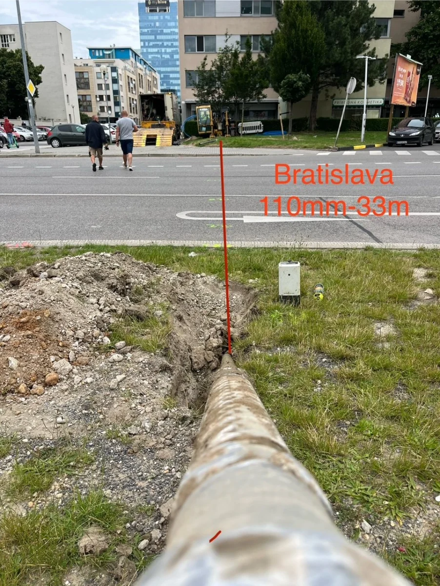 Potrubie vyvedené do zeleného pásu po pretlaku popod mestskú komunikáciu v Bratislave.