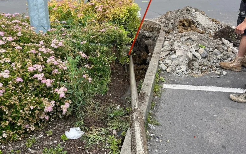 Potrubie zatiahnuté popod parkovisko v Lučenci, pri obrubníku a zelenom ostrovčeku.